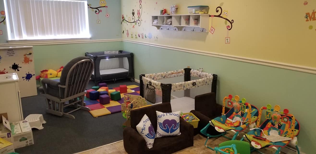 Nursery room with cribs, rocking chair, and play mat