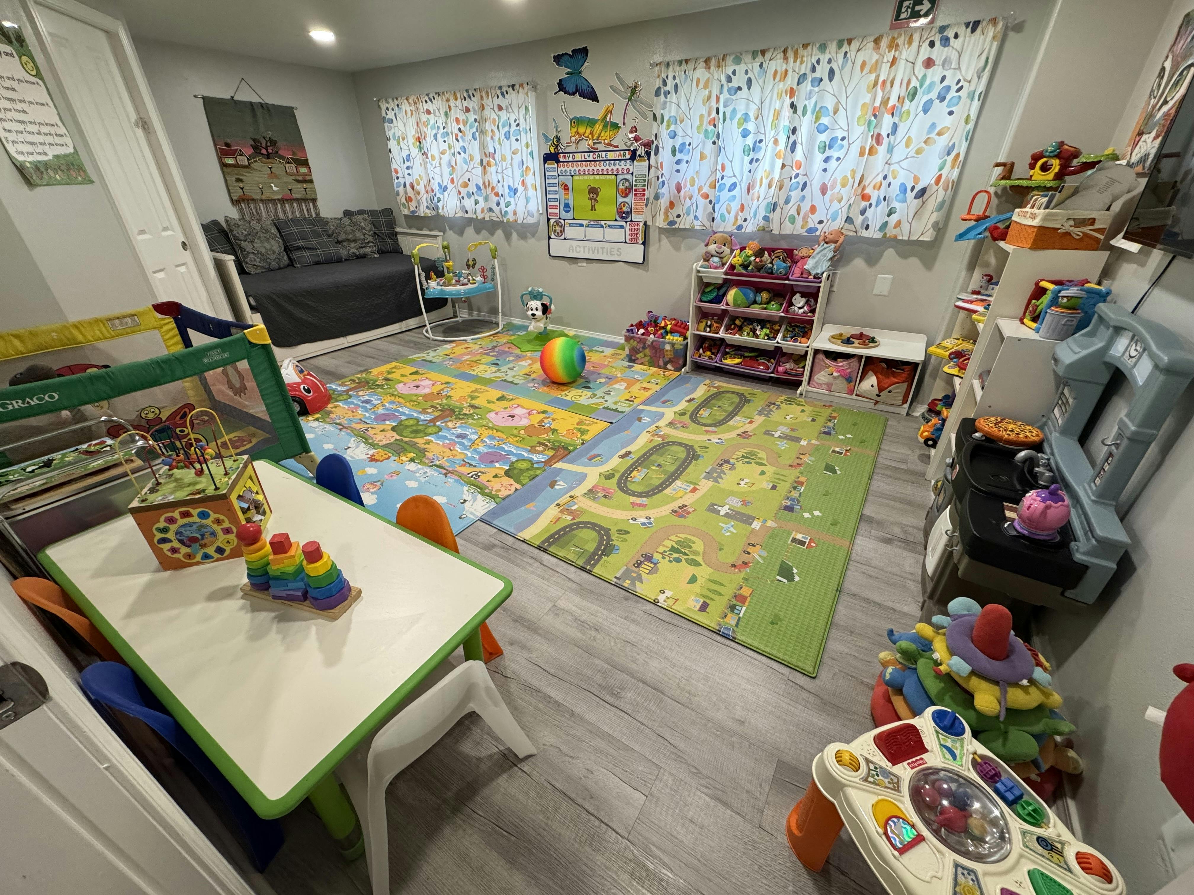 Playroom with colorful activity mats, children's furniture, and various toys