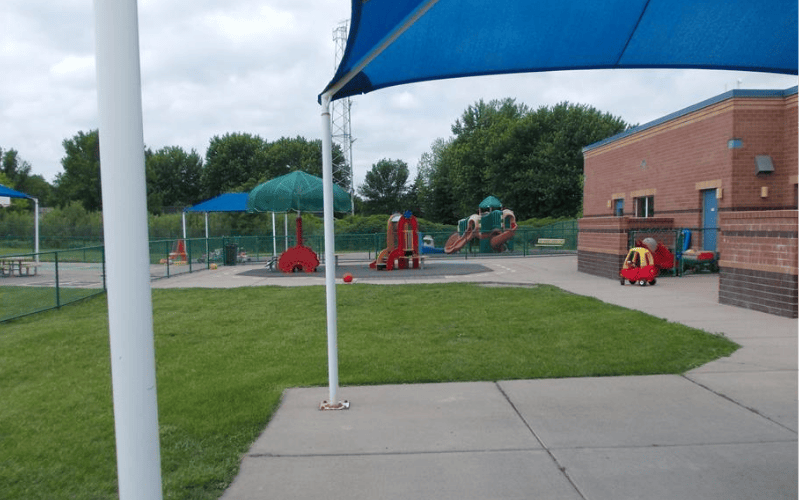 An outdoor playground area with various equipment, including swings and slides