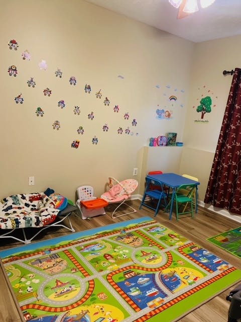 Playroom with a road map rug, small table and chairs, and baby bouncer