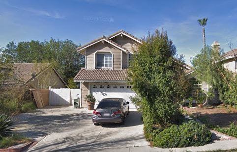 Two-story house with a car parked in the driveway