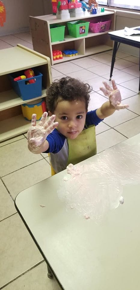 Child with messy hands at a table