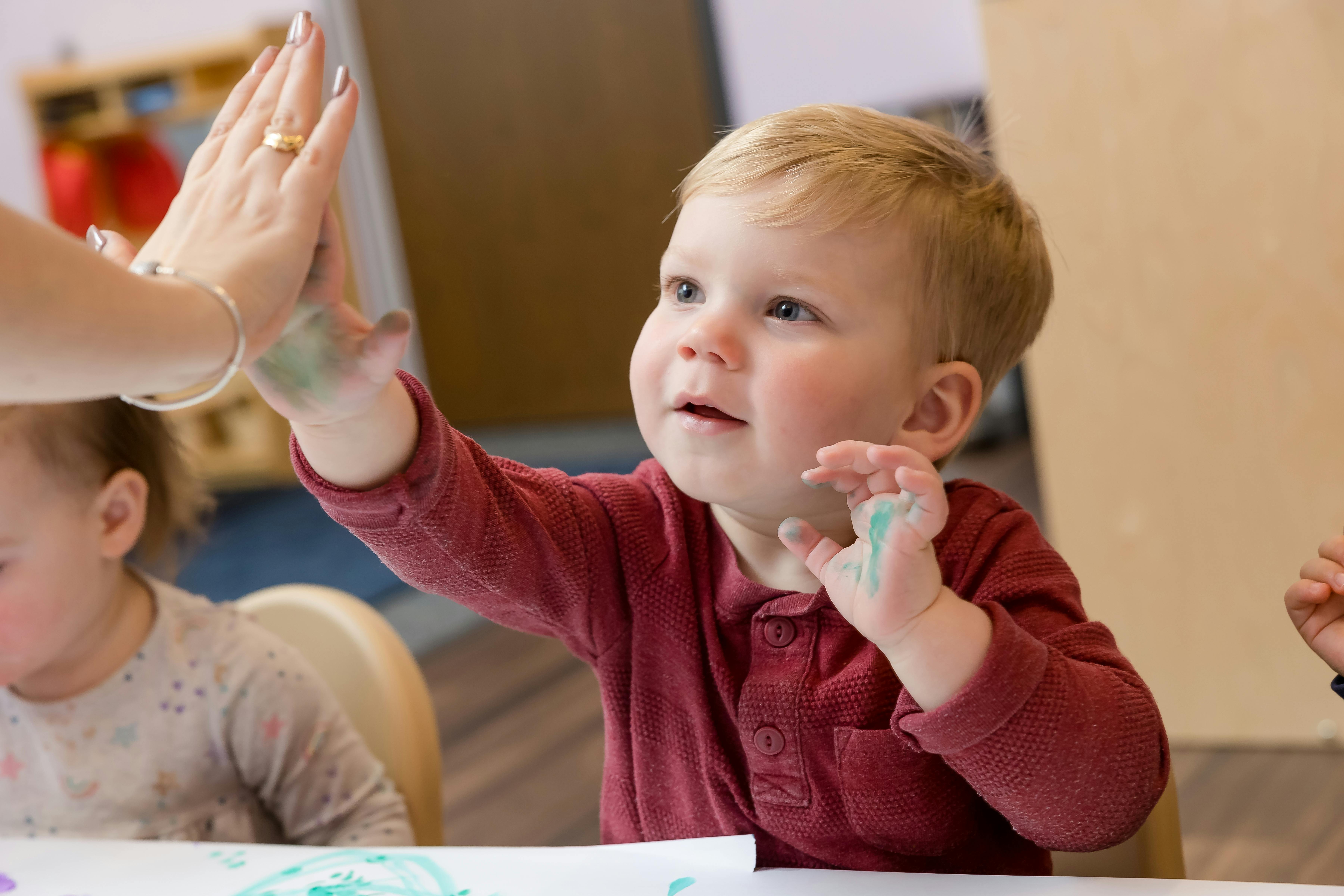 Child giving a high five to an adult