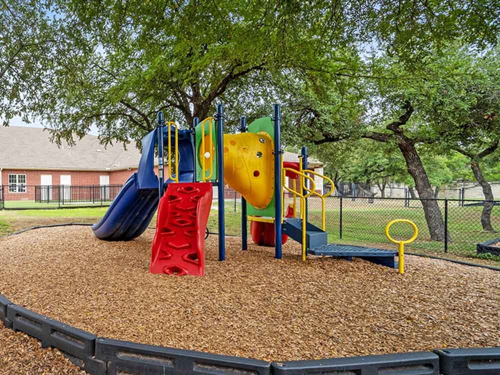 Colorful playground with slides and climbing wall over wood chips