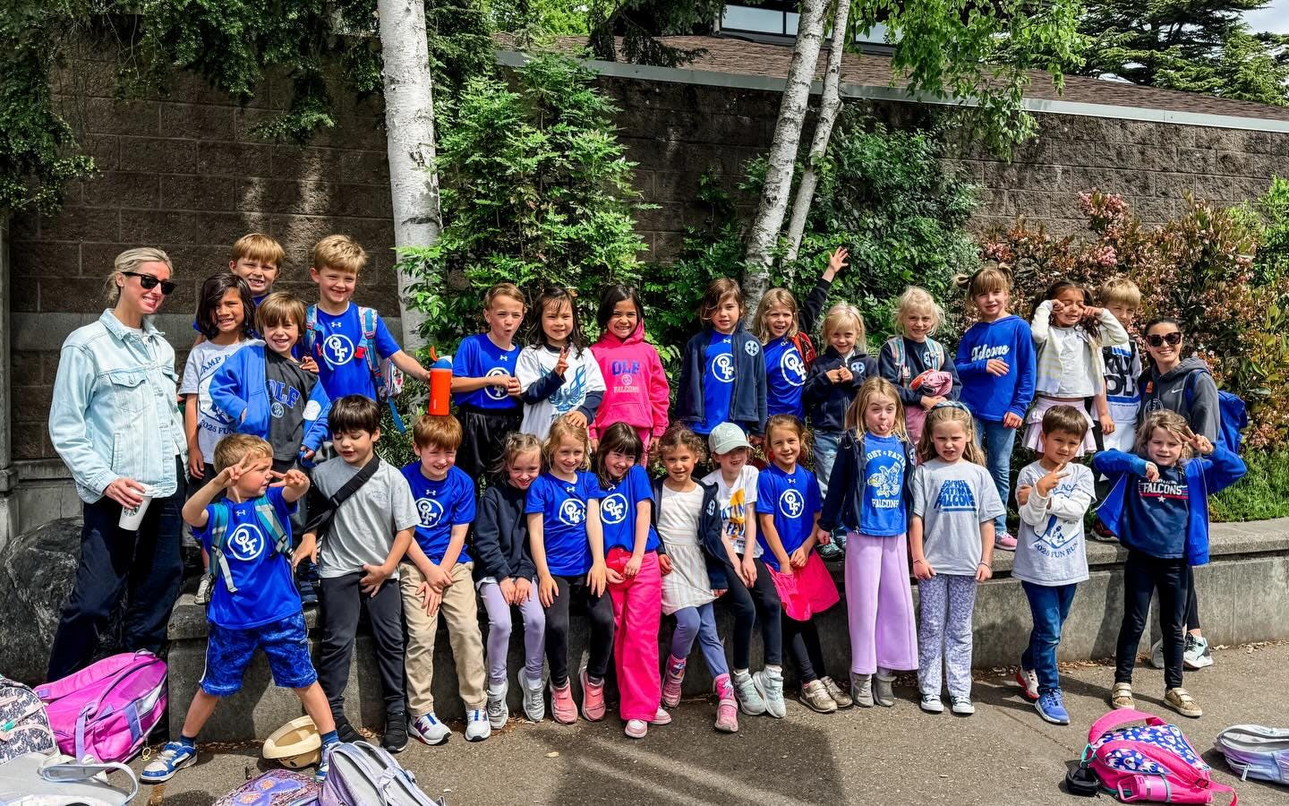 One adult and many children posing together outdoors