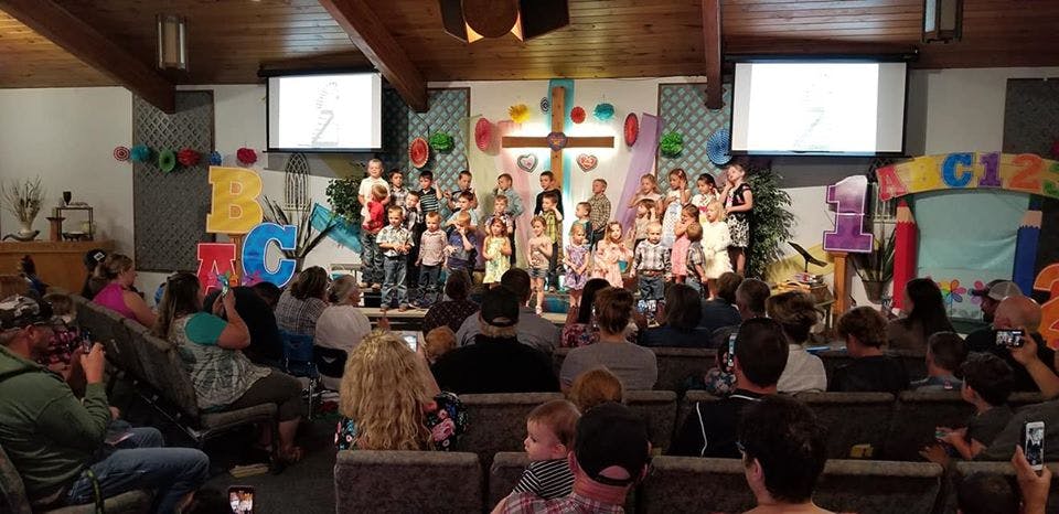 Children performing on a stage in front of an audience