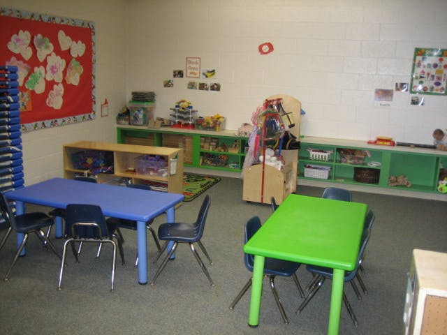 Classroom with small blue and green tables and chairs