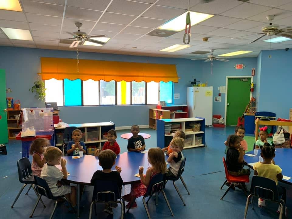 Children sitting at tables in a classroom