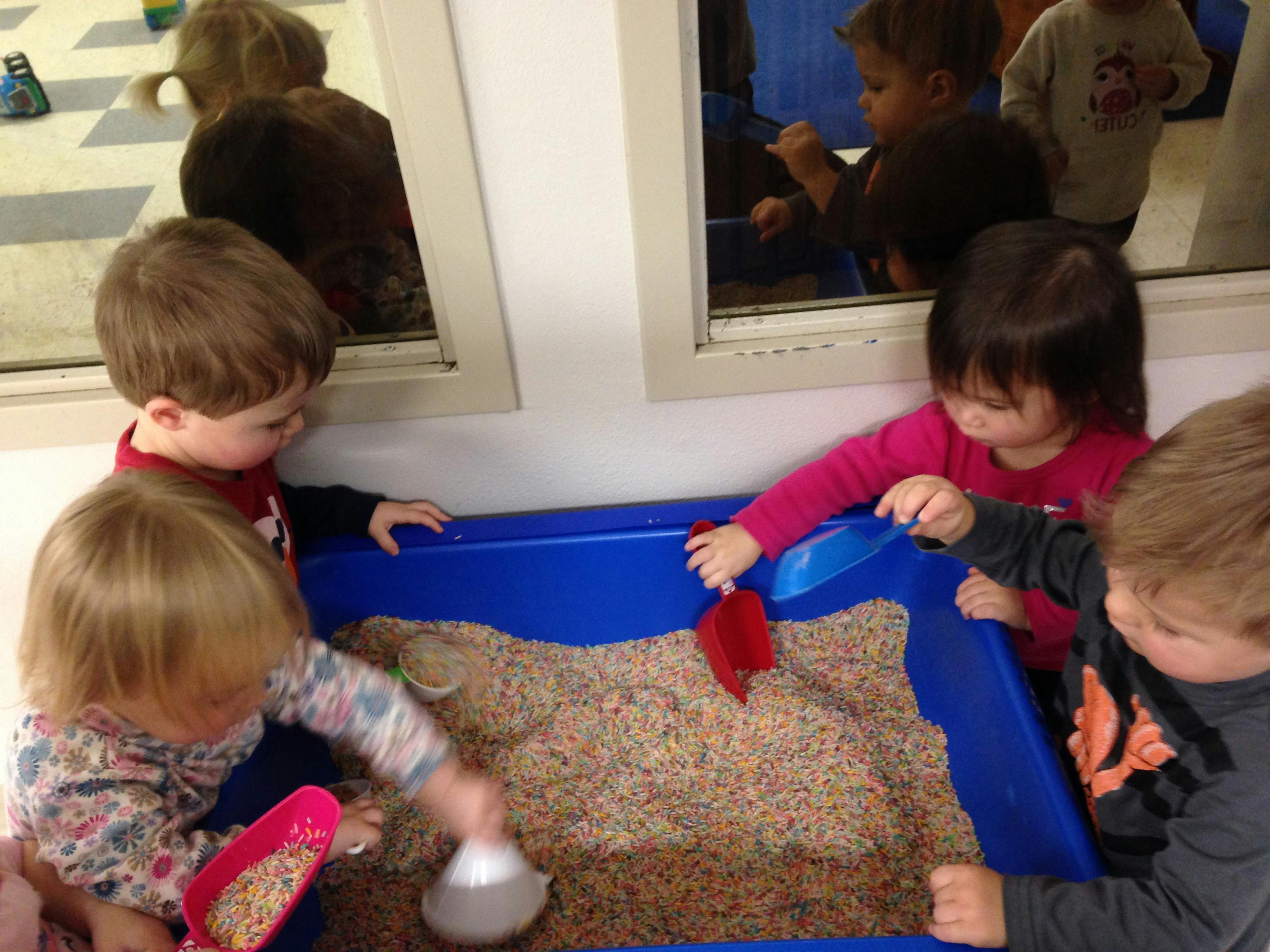 Children playing with sensory bin in a classroom