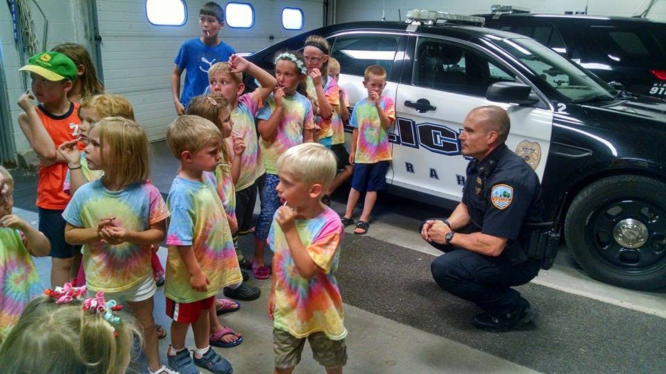 Police officer kneeling with a group of children