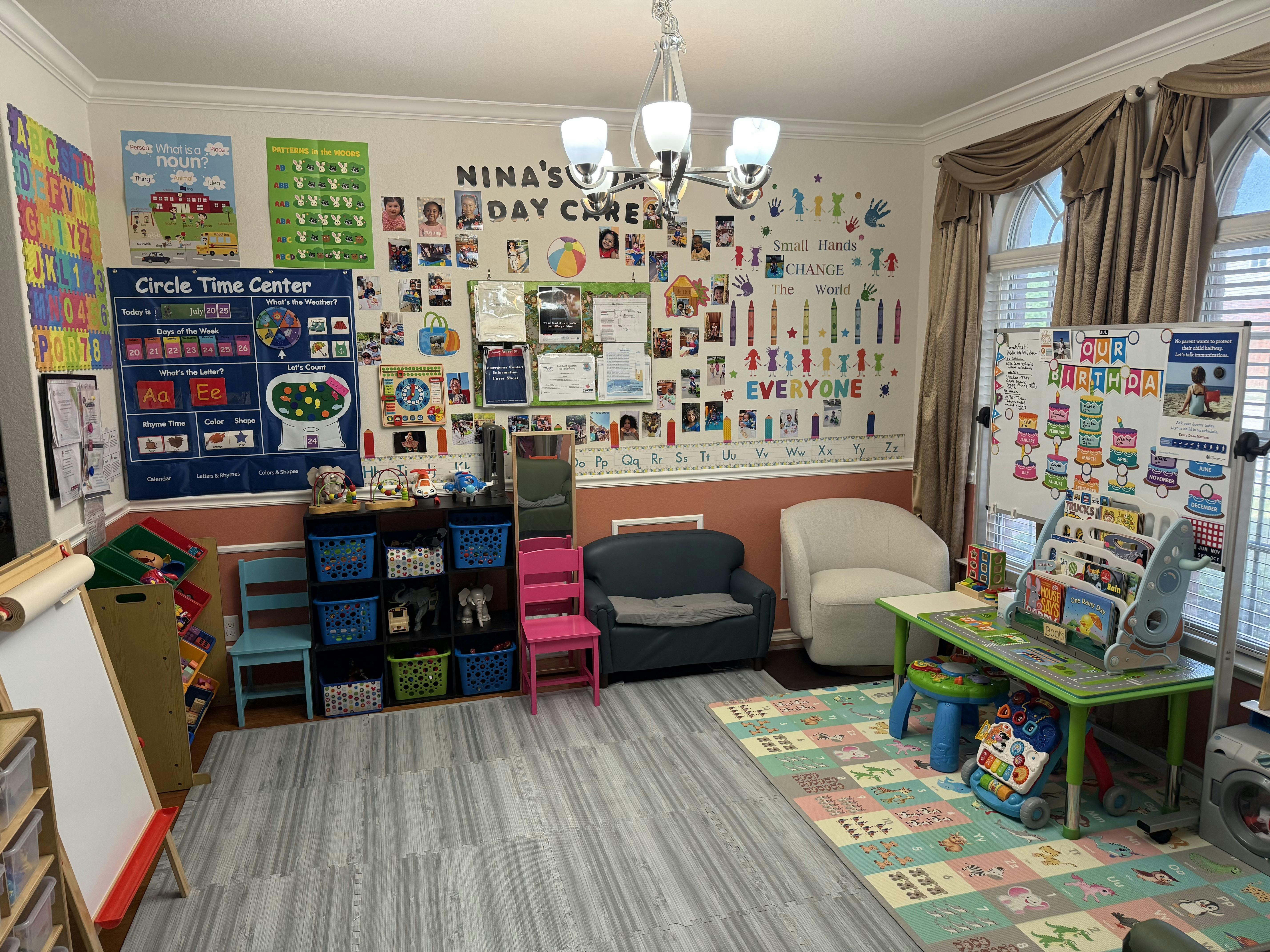 Colorful daycare room with educational wall posters, play furniture, and rugs