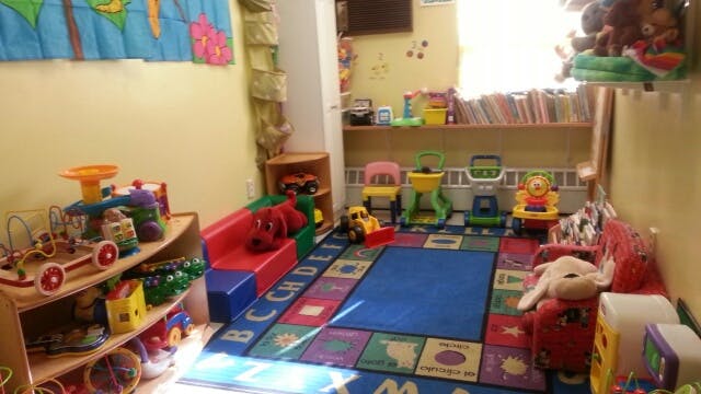 Playroom with toys, colorful rug, and shelves