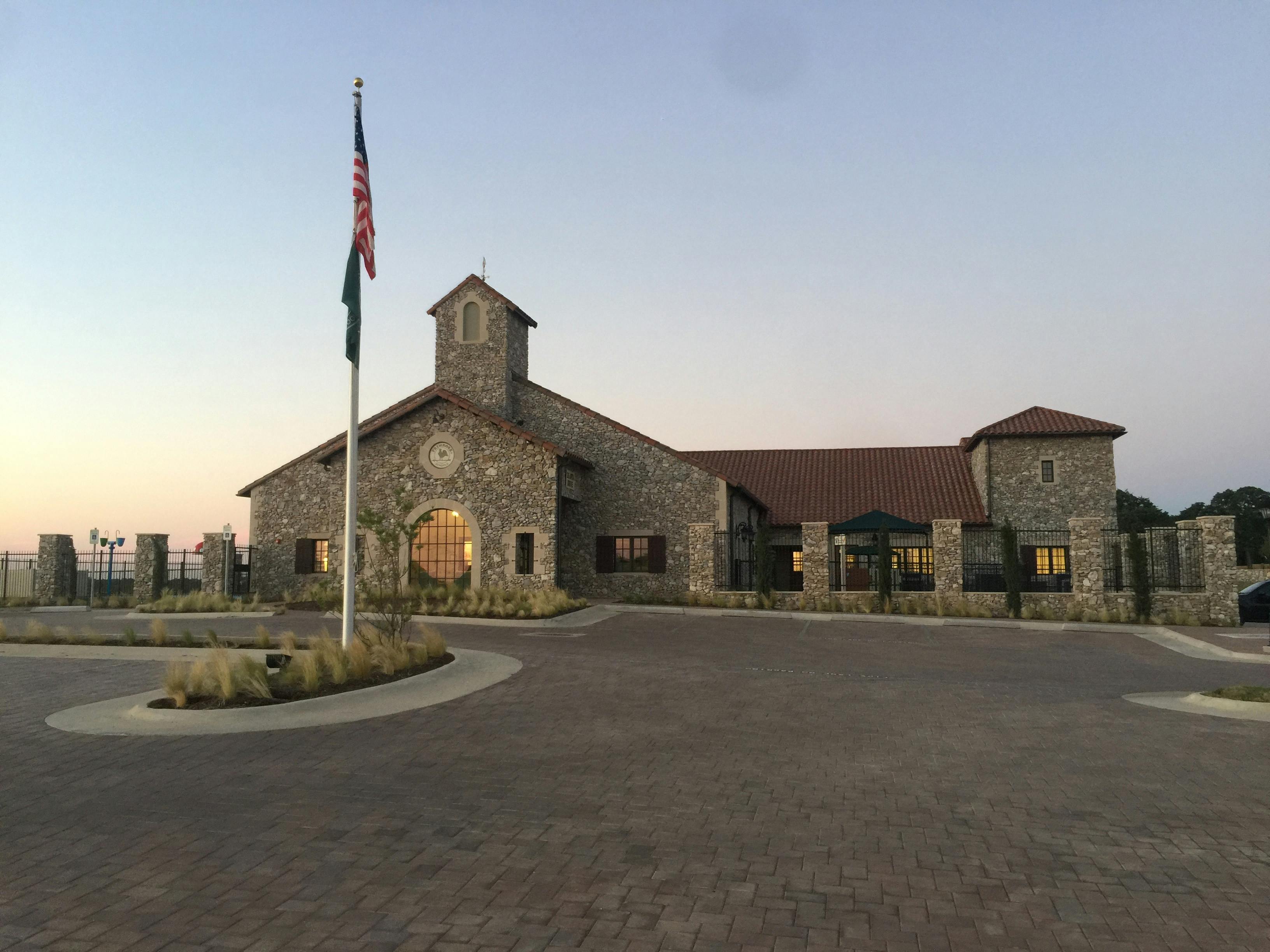 Stone building with a tower and a flag pole in front