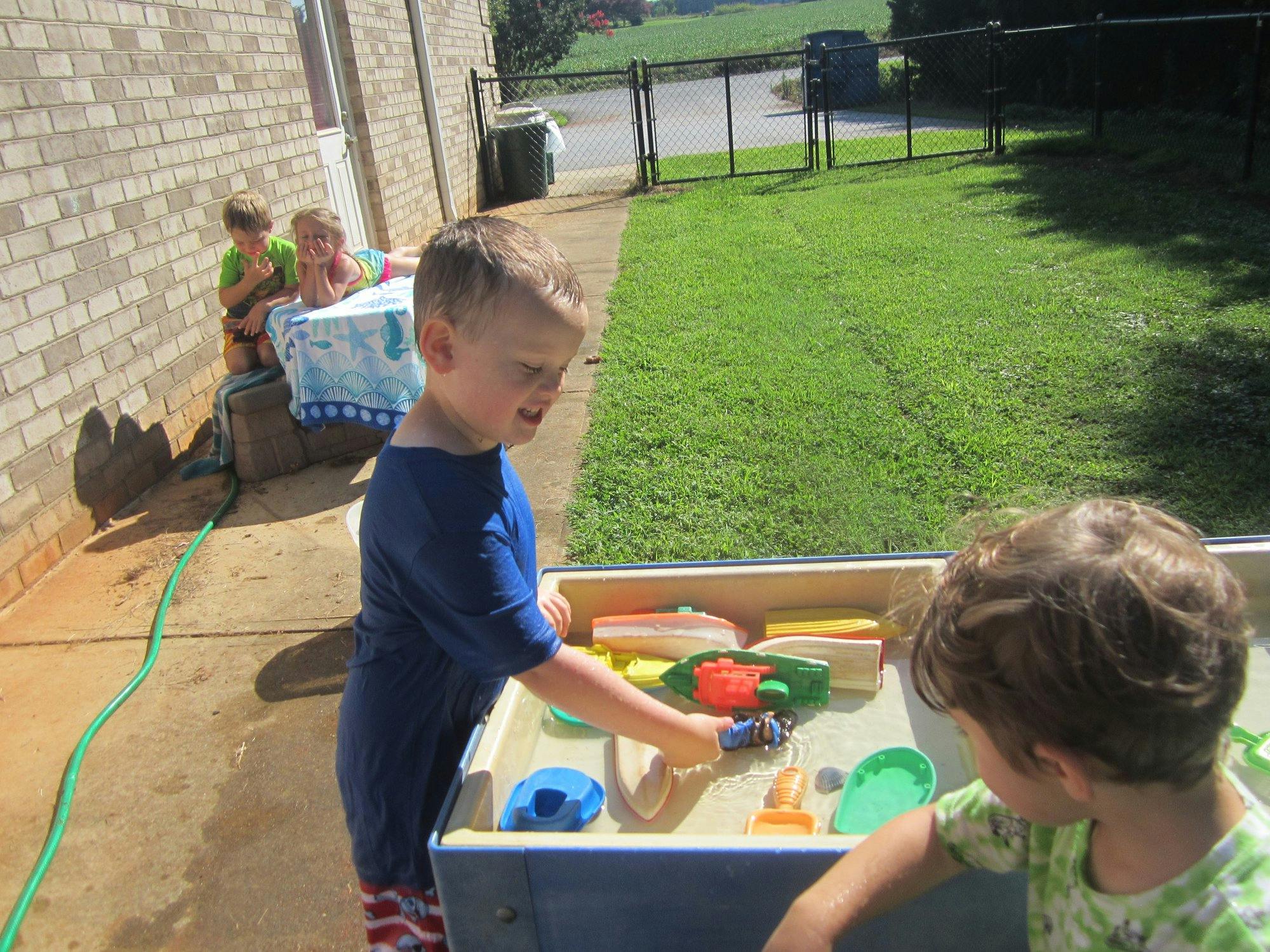 Child playing in a sand and water table outdoors