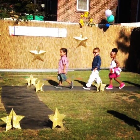 Three children walking on a path with star decorations