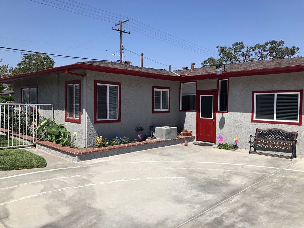 Exterior of a house with a red door and a bench