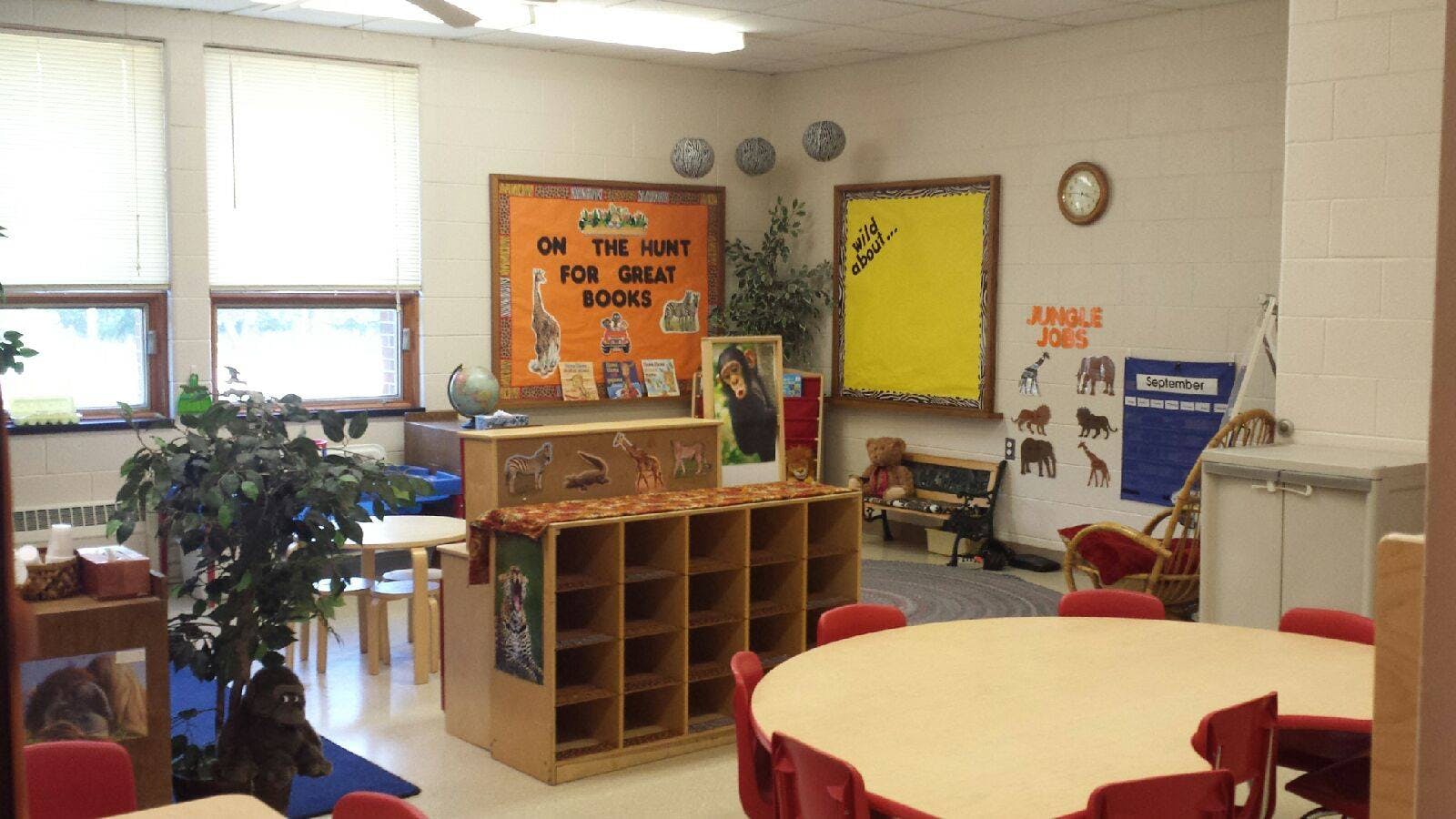 Classroom with tables, chairs, storage cubbies, and bulletin boards