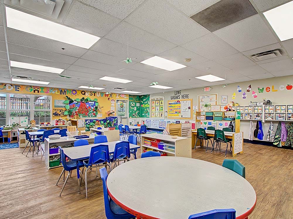 Empty colorful children's classroom with tables, chairs, and decorations