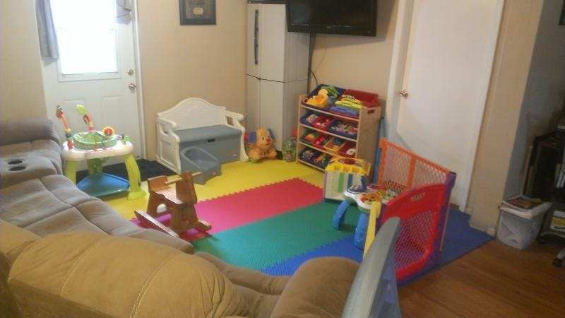 Living room with a colorful play mat and various child toys
