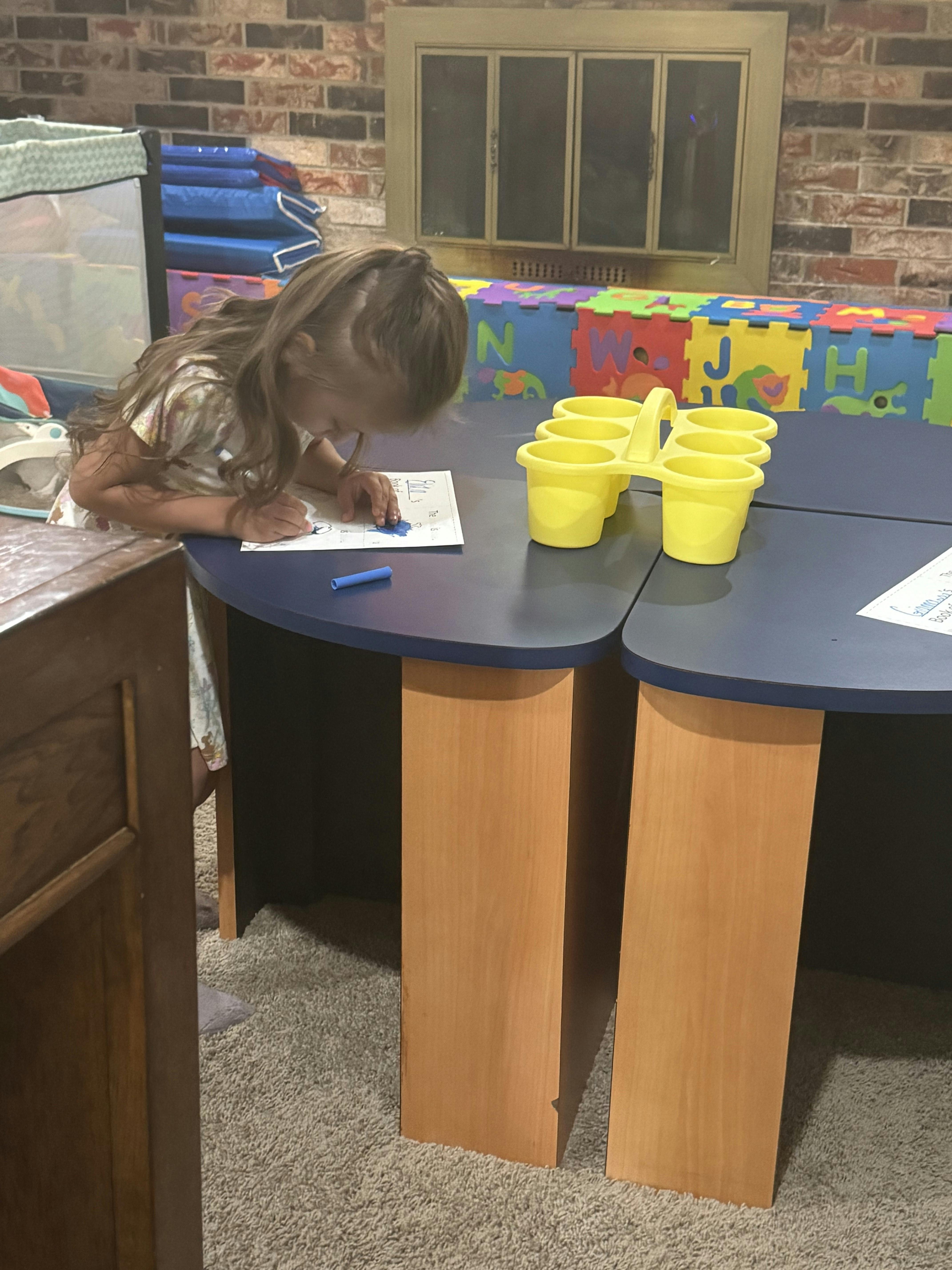 Child writing or drawing on paper at a table