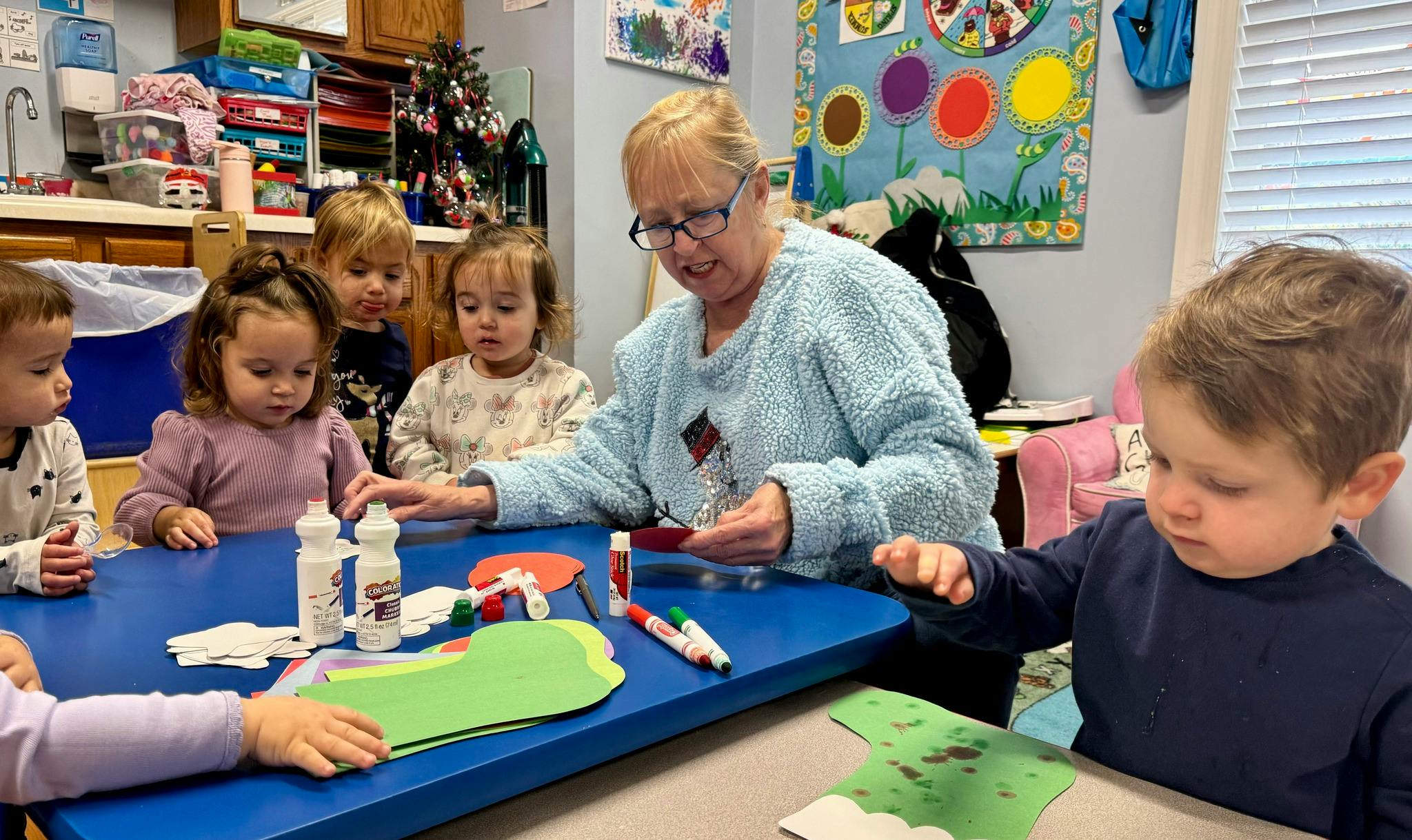 Adult and children doing crafts at a table