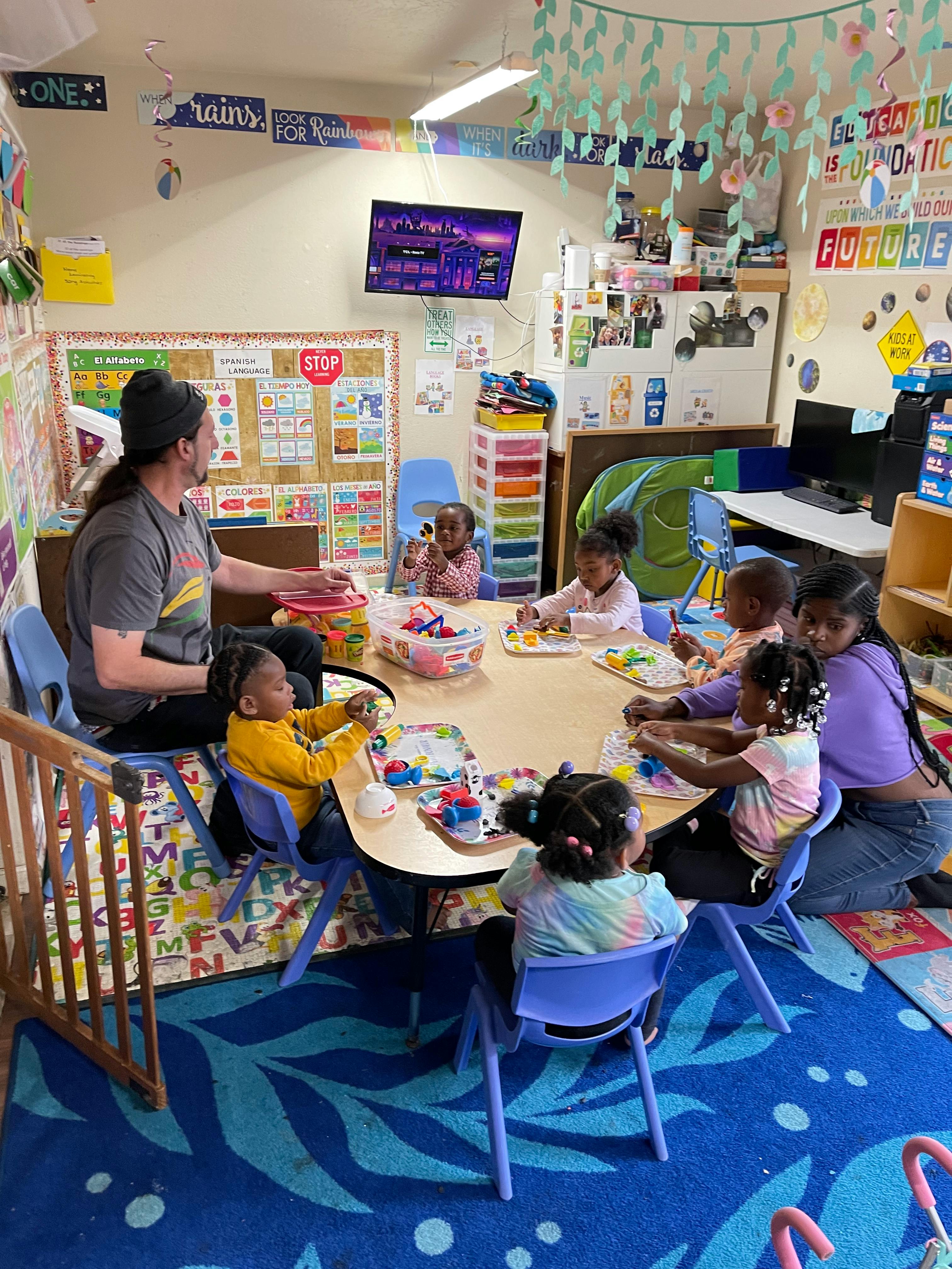 Person and children at a table in a classroom
