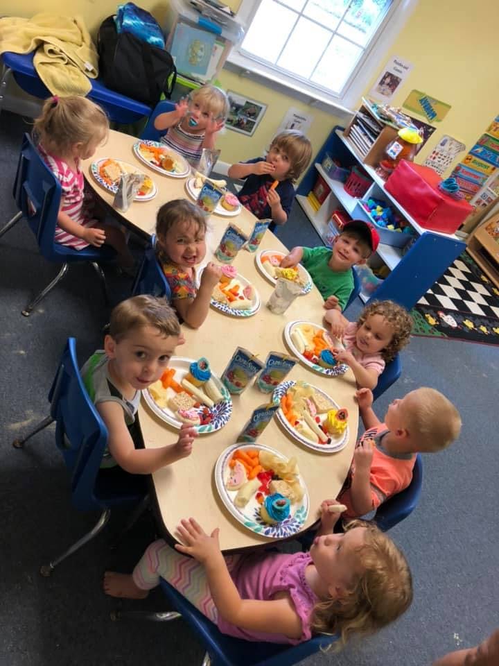 Children sitting at a table with plates of food