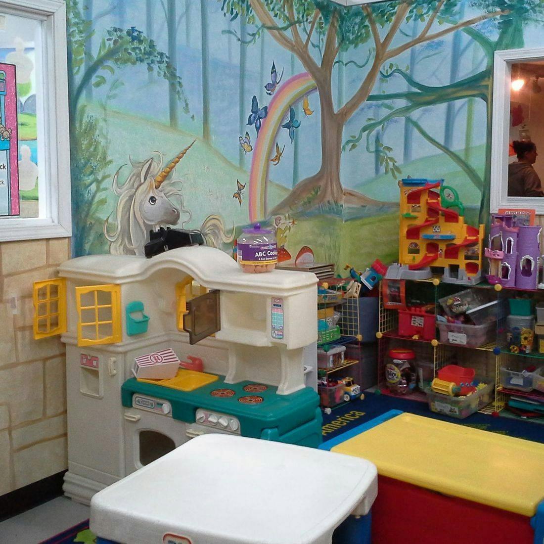 Play kitchen with a unicorn toy and other toys in a room