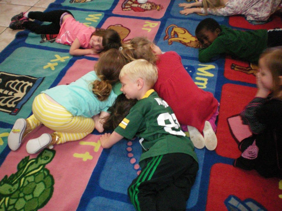 Children lying on a colorful rug