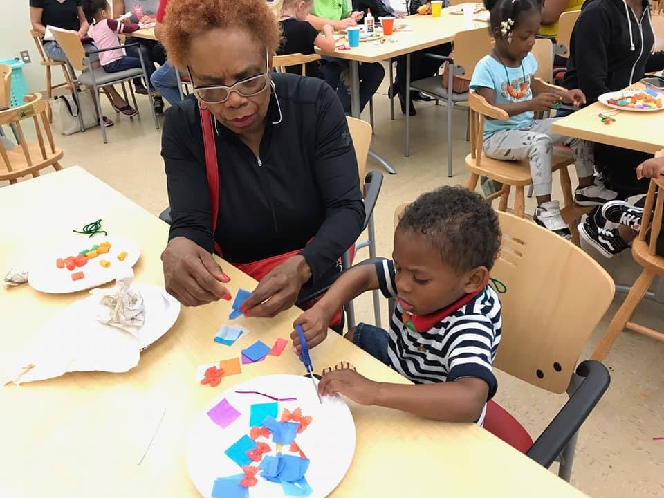 Person and child doing crafts at a table