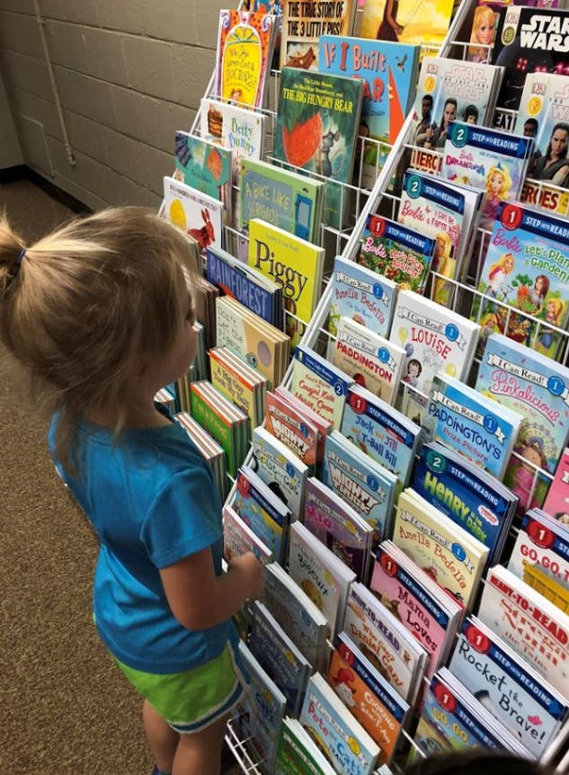 Child looking at books on a display rack