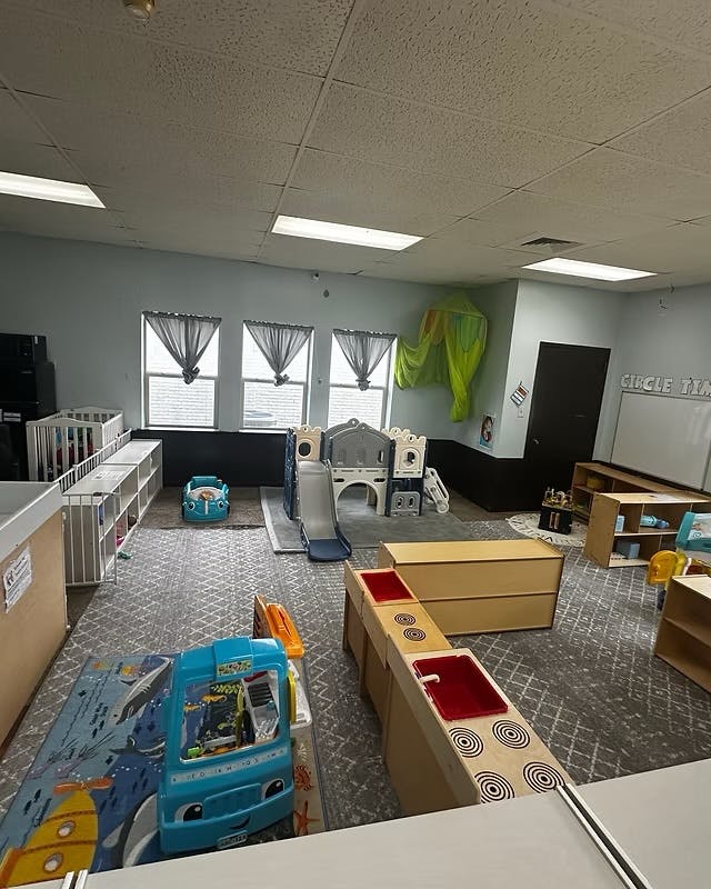 Childcare room with toys, play structures, and cribs