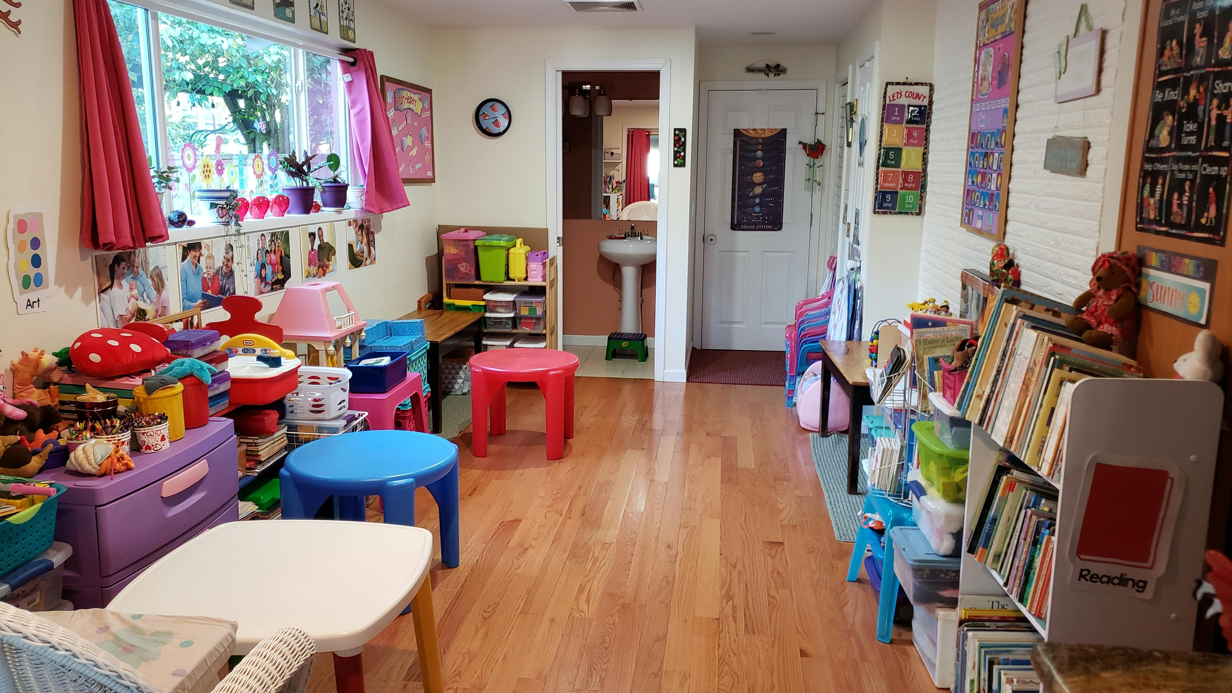 Playroom with small tables, chairs, toys, and books