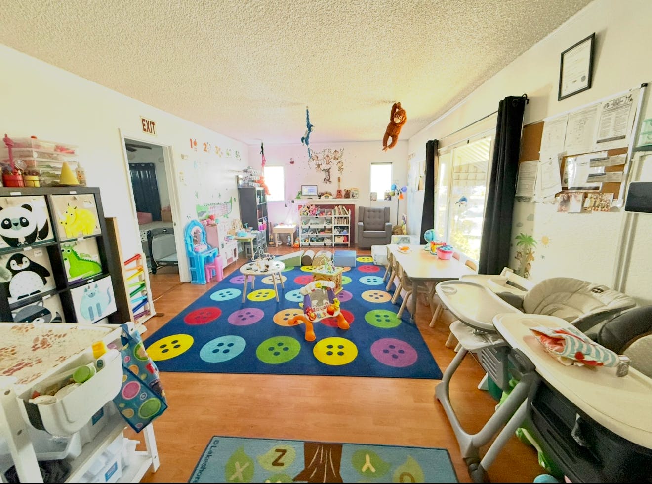 Playroom with a colorful rug, toys, and small tables