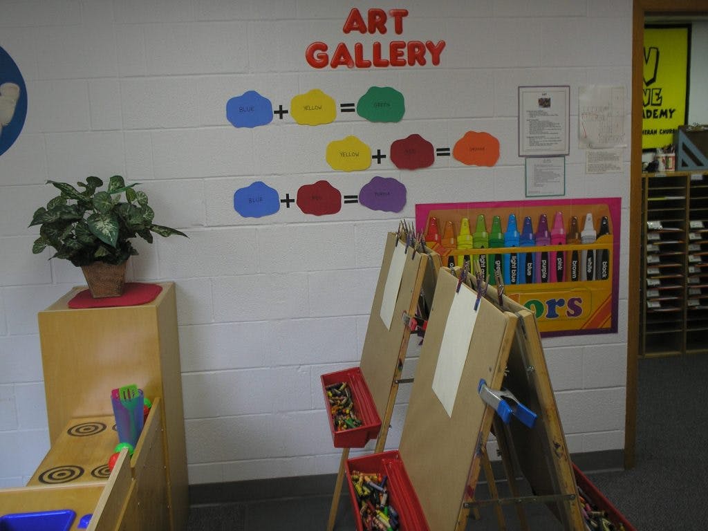 Art gallery sign with color mixing examples and easels in a classroom
