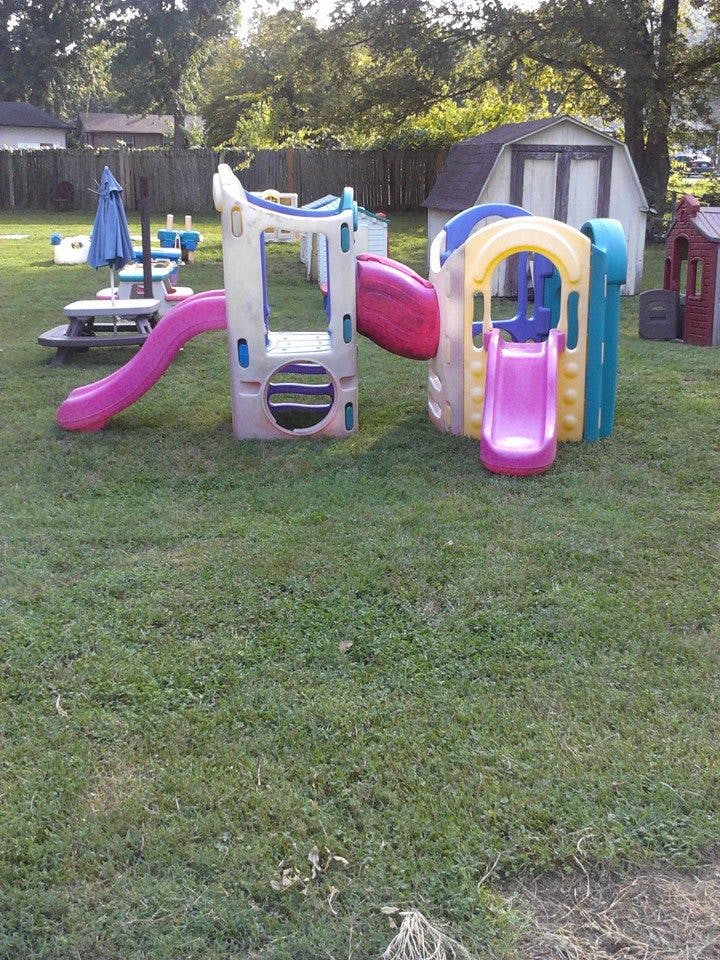 Children's playground equipment with slides and climbing structures on grass