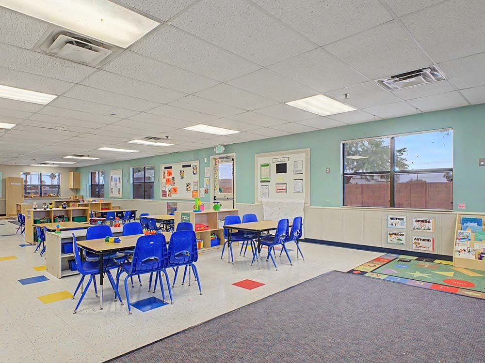 Empty classroom with small tables and blue chairs