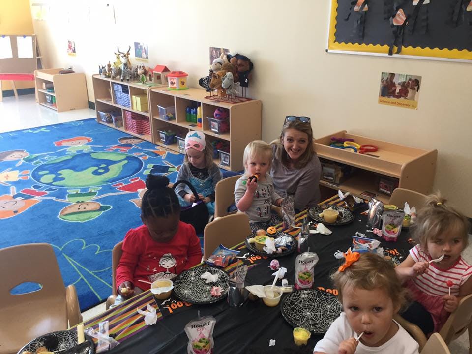 Adult and children sitting at a table in a classroom