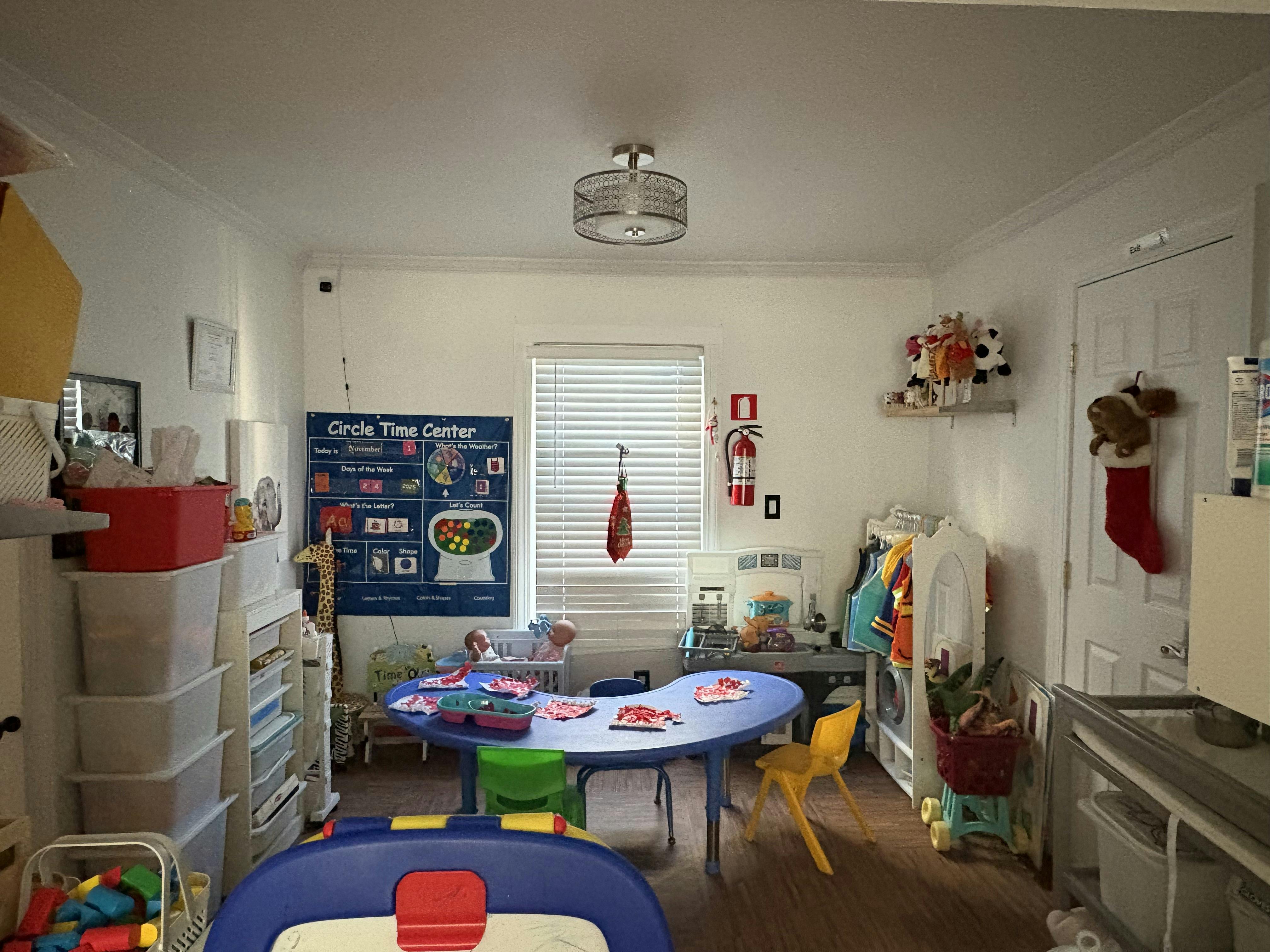 A classroom with a blue table, chairs, and learning materials