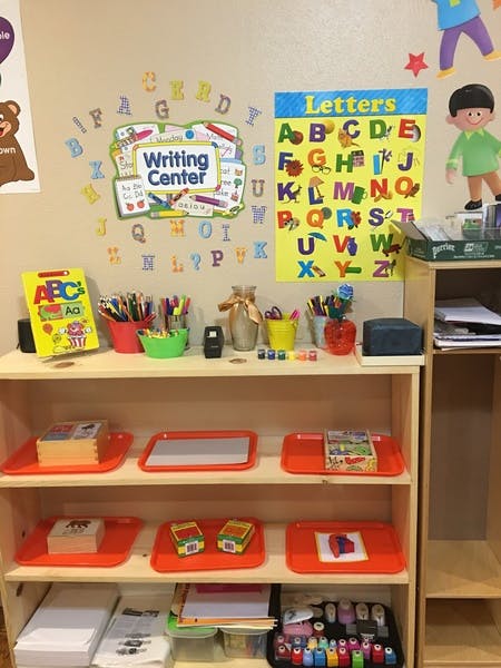 Writing Center sign and alphabet posters above shelves with learning materials