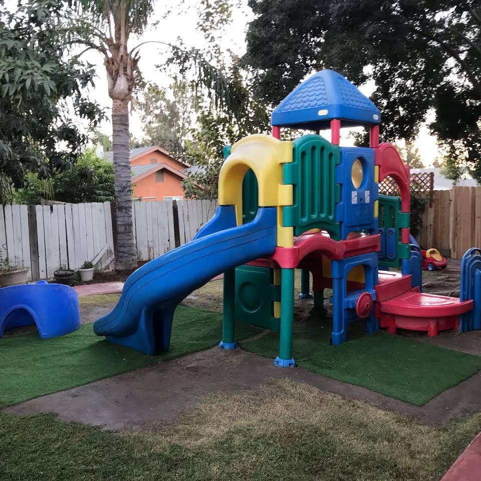 Colorful playground structure with a blue slide on artificial turf
