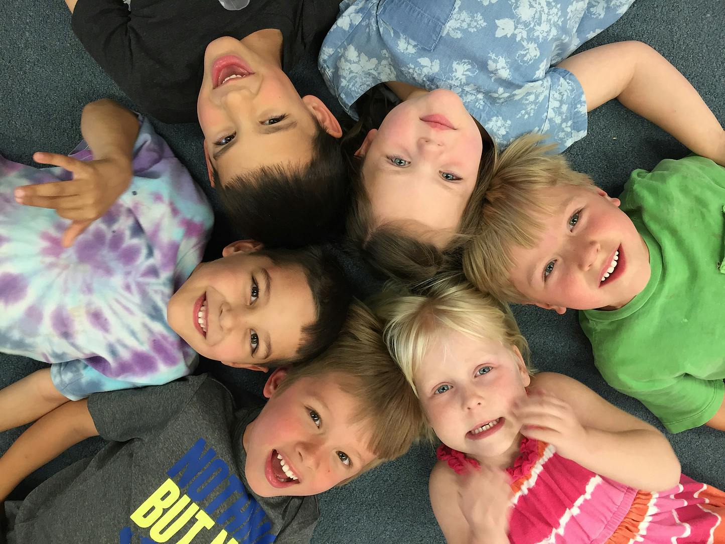 Group of children lying in a circle looking up