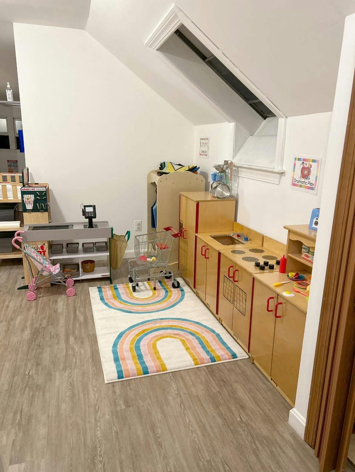Playroom with toy kitchen, toy shopping cart, and rainbow rug