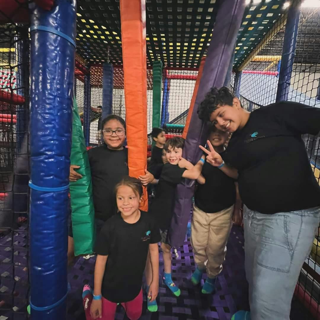 People and children in an indoor play structure