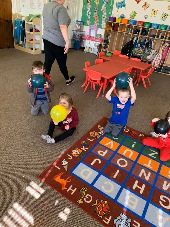 Children playing with balloons in a classroom