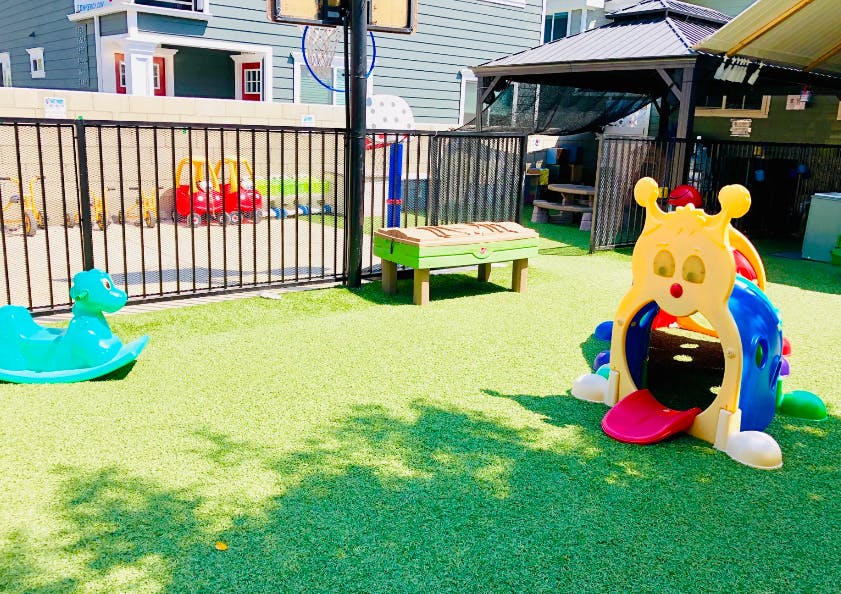 Playground with a plastic play structure and a rocking toy