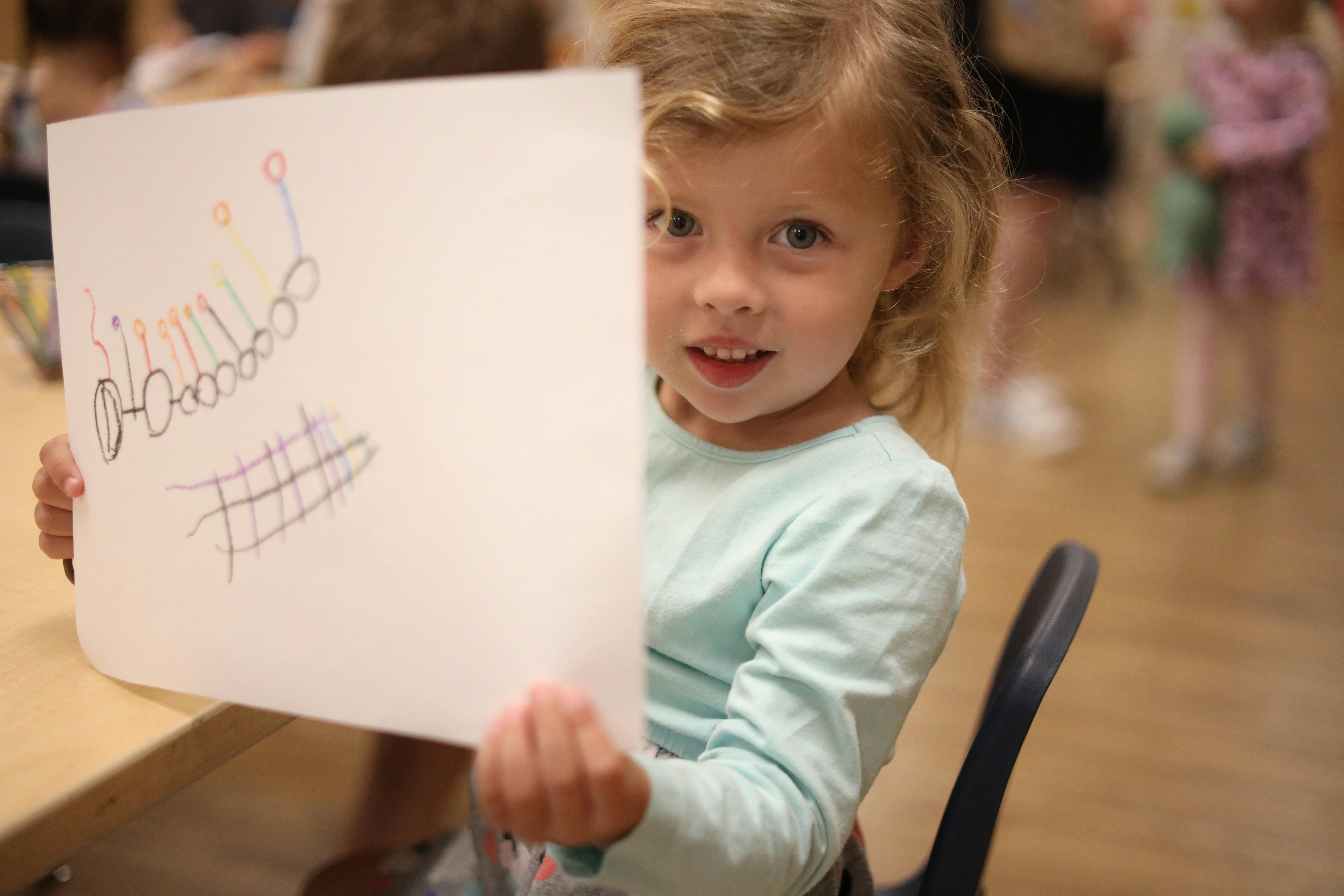Child holding up a drawing