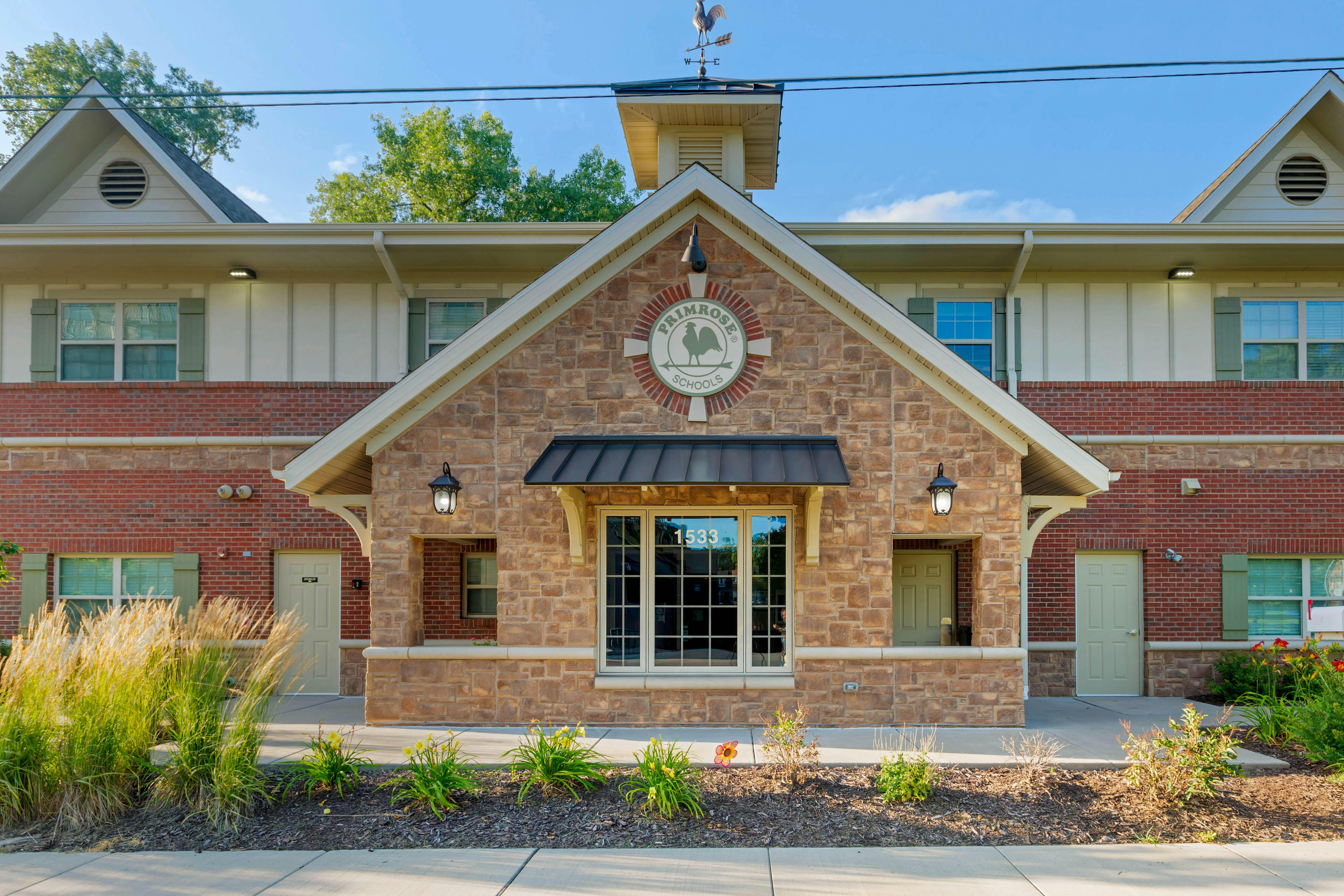 Brick building with a central gabled entrance and a cupola