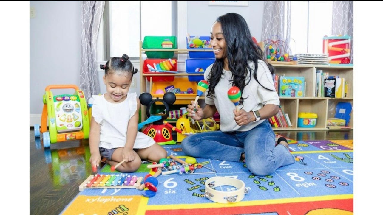 Adult and child playing with musical instruments on a mat