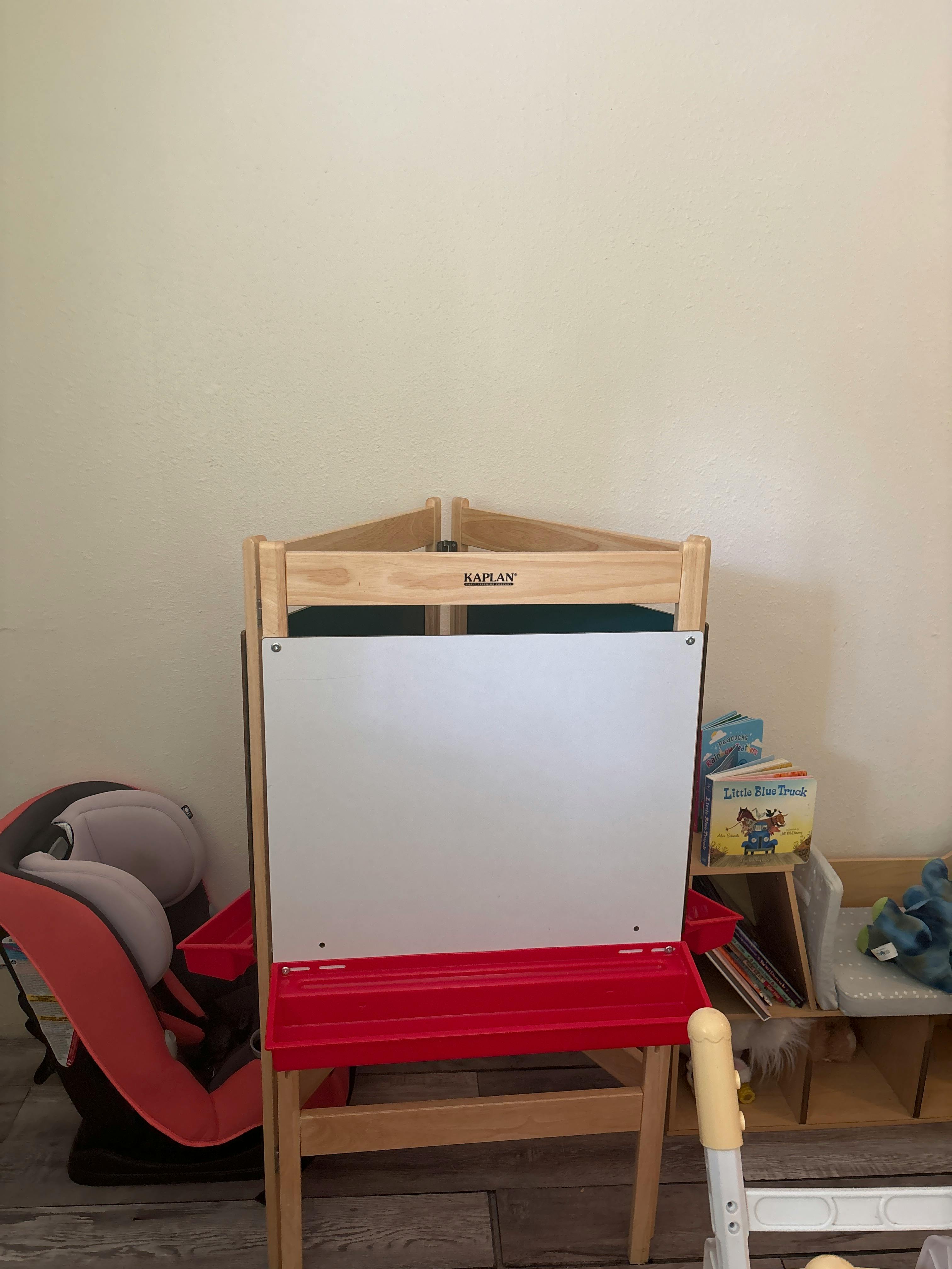 Wooden easel with a white board and red tray